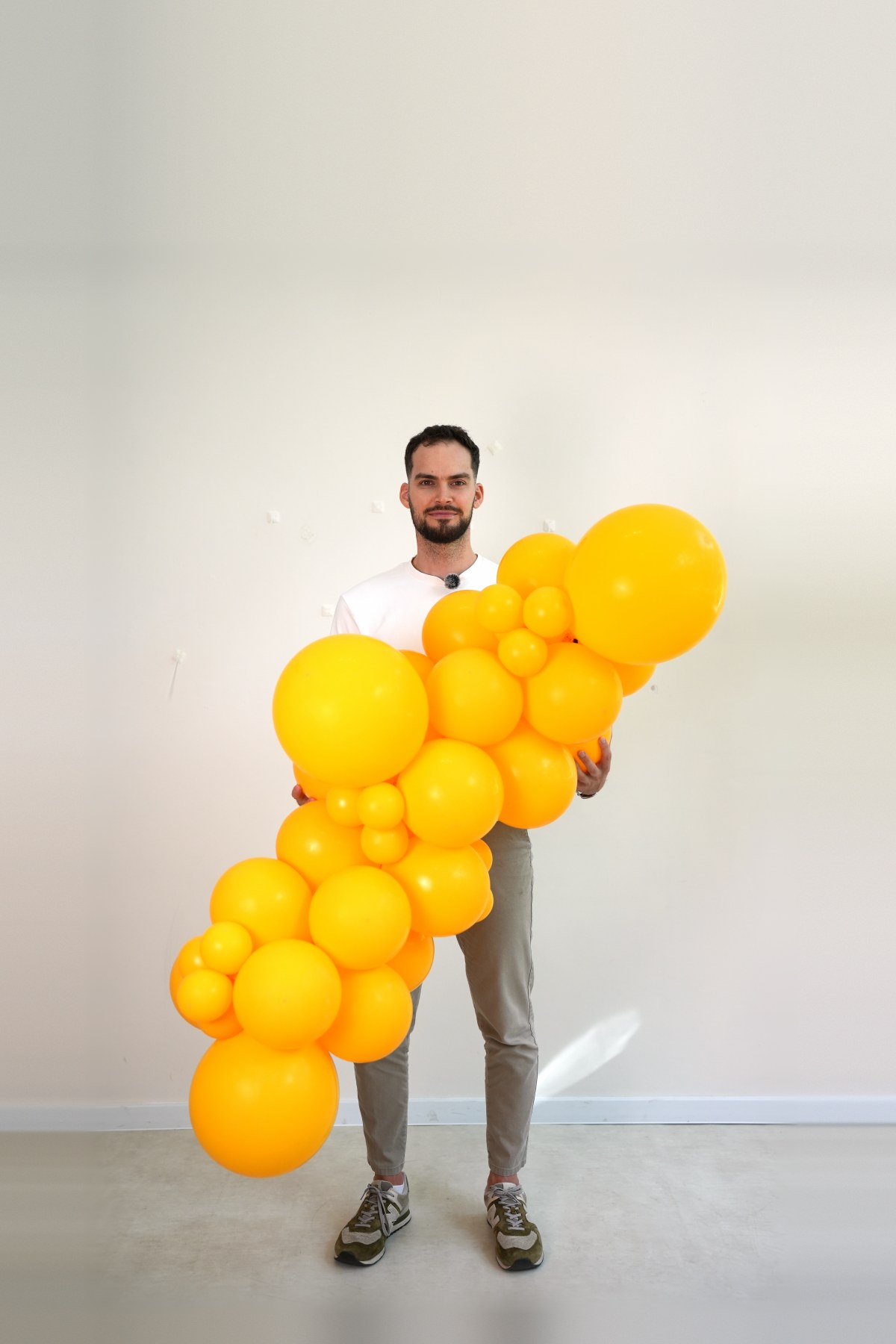 Girlanda balonowa o długości ok. 1,5 m trzymana przez osobę o wzroście 187 cm